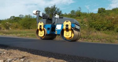 Yeni yolda asfalt sıkıştırılmış yol, tamamlanmış iş. Yol silindiri - Toprak, çakıl, beton veya asfalt yapımında kullanılan sıkıştırıcı tipi mühendislik aracı