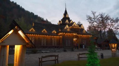 YAREMCHE, CARPATHIANS, UKRAINE, EKİM 16 Ekim 2022: Batı Ukrayna 'daki Yaremche şehrindeki ünlü Hutsulshyna restoranının yakınındaki insanlar. Hutsulshchyna restoranının ahşap binası, mimarlık abidesi.