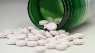 Farmakolojik biyokimya, ilaç tedavisi. Aşırı doz veya zehirlenme. Yüksek dozlar ve yan etkiler. Masada haplar ve yeşil kavanoz var. İlaç maddesi, ilaç tedavisi, ilaçların verdiği hasar.