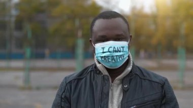 Tıbbi maskeli Afro-Amerikalı bir eylemci ve tek bir grevde 