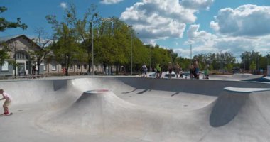 KYIV, UKRAINE, 26 Temmuz 2022: Kyiv şehrindeki çok amaçlı sergi kompleksi Ukrayna 'nın merkezindeki yeni açık hava spor sahasında erkekler scooter sürüyor