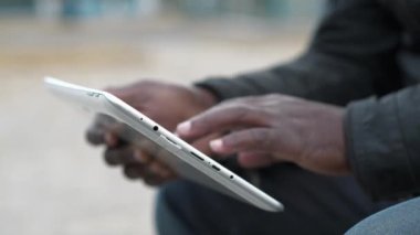 Afro-Amerikan erkek elleri tablet bilgisayarı tutuyor, kapat. Adam tablet bilgisayar kullanıyor, sosyal ağlarda görüntü aktarıyor