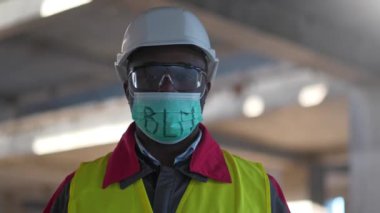 Siyah şapkalı, koruyucu gözlüklü ve tıbbi maskeli Afro-Amerikan işçiler kameraya bakıyor. Siyahların Yaşamı Önemli, BLM, ABD 'de toplu protestolar