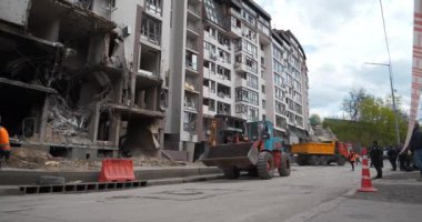 UKRAINE, KYIV, 29 Nisan 2022: bombardımandan sonra. Kalan ev 28 Nisan 2022 'de Rus füzesiyle hasar gördü. İşçiler bombalamadan sonra molozları temizler. Ukrayna 'da savaş. Ukrayna halkına terör ve soykırım