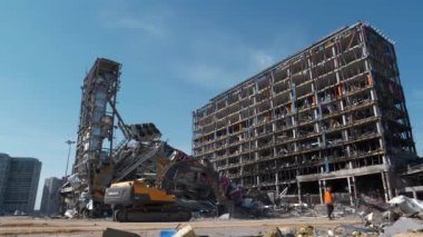 KYIV, UKRAINE, 15 Nisan 2022: Rus füzesi 20 Mart 2022 tarihinde Kyiv 'deki alışveriş ve eğlence merkezi Retroville' i yok etti. Bombalamadan sonra. Kazıcı molozları temizliyor. Ukrayna 'da Savaş