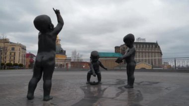 KYIV, UKRAINE, APRIL 20, 2022: Monument to the founders of Kyiv - Kiy, Shchek, Khoriv. Small children, brothers, playing with paper boats. River port, Postal square in Kyiv city, capital of Ukraine