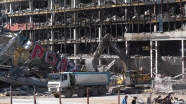 KYIV, UKRAINE, 15 Nisan 2022: Rus füzesi 20 Mart 2022 tarihinde Kyiv 'deki alışveriş ve eğlence merkezi Retroville' i yok etti. Bombalamadan sonra. Kazıcı molozları temizliyor. Ukrayna 'da Savaş