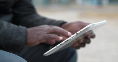 Siyah adamın elleri tablet bilgisayarı tutuyor, kapat. Afrikalı Amerikalı adam tablet bilgisayar kullanıyor, sosyal ağlarda görüntülere göz atıyor. Sinema 4K 60fps video