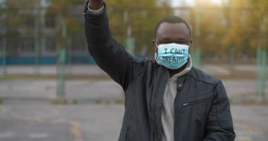 Tıbbi maskeli Afro-Amerikalı bir eylemci ve tek bir grevde 