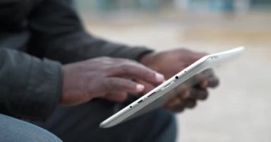 Afrika kökenli Amerikalı adam tablet bilgisayar kullanıyor. Siyah adamın elleri tablet bilgisayarı tutuyor, kapat. Tablet bilgisayarlı Afrikalı çalışmalar, sosyal ağlar üzerinden yayın yapıyor. Sinema 4K 60fps video