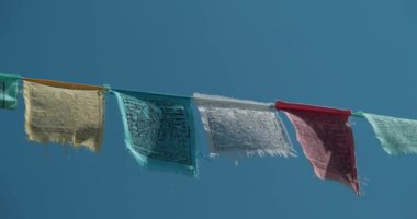 Tibet dua bayrakları - renkli dikdörtgen kumaşlar, Himalayalar 'ın yüksek tepelerinde ve patikalarda sıklıkla bulunur. Sinema 4K 60fps video