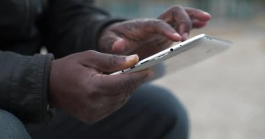 Afrikalı Amerikalı adam tablet bilgisayar kullanıyor. Siyah adamın elleri tablet bilgisayarı tutuyor, kapat. Tablet bilgisayarlı Afrikalı çalışmalar, sosyal ağlar üzerinden yayın yapıyor. Sinema 4K 60fps video
