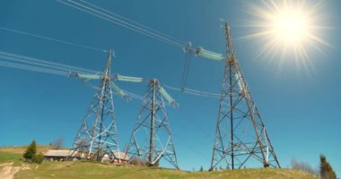 Üç büyük elektrik iletim kulesi ve güneş