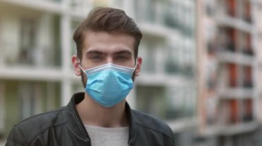 Tıbbi koruyucu maskeli yakışıklı adam kameraya bakıyor. Covid konsept sağlık ve güvenlik, koronavirüs karantinası, sosyal uzaklık, bir sonraki dalga covid virüs koruması