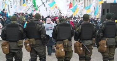 KYIV, UKRAINE, 22 Aralık 2020: Çevik kuvvet, münferit girişimcilerin adil olmayan yasalara, Kyiv, Ukrayna 'daki protesto toplantısında bayraklı kalabalığa bakıyor. Sinema 4K 60fps video