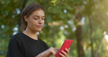 Güzel genç kız onun akıllı telefonundaki fotoğraflara bakıyor ve göz gezdiriyor. Sinema 4K 60fps video