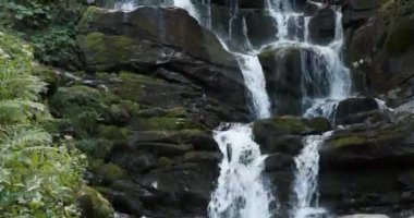 Dağlardaki şelale manzarası, Ukrayna 'daki Karpat Dağları' nın vahşi doğası. Sinema 4K 60fps eğik video