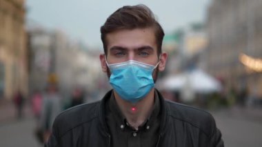 Ağır çekim maskeli genç adam sokakta dikiliyor ve sana bakıyor. Kırmızı lazer ışını yükselir ve alnında parlar, adam gözlerini kapar ve atışını bekler.