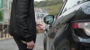 Slow Motion Man arabasına yaklaşır, kapı kolunu çeker, anahtarları unuttuğunu anlar ve sinirli bir şekilde ayrılır.