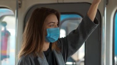 Mavi tıbbi koruyucu maskeli genç bir kadın metro vagonuna biniyor. Covid konsept sağlık ve güvenlik, N1H1 koronavirüs karantinası, bir sonraki dalga covid virüs koruması