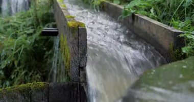 Su, ahşap bir oluktan akar. Valilo - doğal çevre dostu çamaşır makinesi, deterjansız büyük eşyaları yıkamak, güçlü bir nehir suyu akışı kullanmak. Sinema 4K 60 fps sesli video