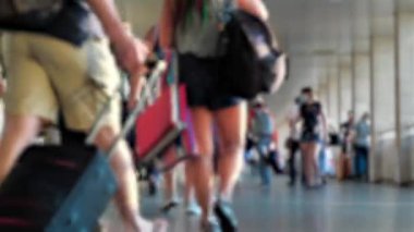 Elinde bavulları olan isimsiz insanlar tren istasyonunun girişinde yürürler.