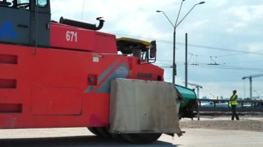 KYIV, UKRAINE, 30 Haziran 2020: Ukrayna 'nın başkenti Kyiv' deki Stepan Bandera Bulvarı 'nda yol silindiri ve asfalt yerleştirme makinesi