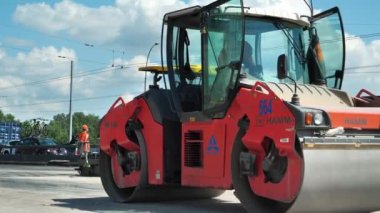 KYIV, UKRAINE, 29 Haziran 2020: yol silindiri ve asfalt yerleştirme makinesi. Ukrayna 'nın başkenti Kyiv' deki Stepan Bandera Bulvarı 'nda yol çalışmaları sürüyor.