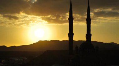 Akşam bulutları, güneş ve Sharm El Sheikh şehrindeki Al Sahaba Camii 'nin iki minaresi, Mısır