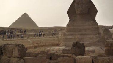 EGYPT, GIZA, CAIRO, 11 ARALIK 2019: Giza 'nın Büyük Sfenksi yakınındaki insanlar, Giza platosundaki Menkaure Piramidine bakın