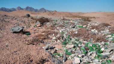 Kırık şişe bardakları çölde, çevreyi suistimal ederek yatıyor. Cullet ve diğer çöpler Mısır 'ın Sharm El Sheikh şehri yakınlarındaki çölde, çevre kirliliği
