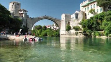 MOSTAR, BOSNIA VE HERZEGOVINA, 3 Temmuz 2019: Bosna-Hersek Federasyonu 'nun Hersek-Neretva Kantonu' nun eski Mostar kenti yakınlarındaki Neretva nehri üzerindeki turistler
