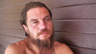 Yoksul adam kamerada konuşuyor. Evsiz adam kameraya bakar ve konuşur. Sabit bir evi olmayan gerçek bir insan.
