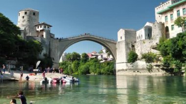MOSTAR, BOSNIA VE HERZEGOVINA, 2 Temmuz 2019: Bosna-Hersek Federasyonu Federasyonu Neretva Kantonu 'nun şehir ve idari merkezi Mostar' daki Neretva Nehri 'nde insanlar yüzüyor