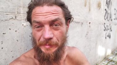 Morali bozuk biri kamerada konuşur. Evsiz adam kameraya bakar ve konuşur. Sabit ikametgahı olmayan gerçek bir insan.