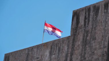 Ağır çekim, Hırvatistan Bayrağı eski Dubrovnik kentinin duvarlarında. Hırvatistan Ulusal Bayrağı - Trobojnica veya Tricolor, ortada Hırvatistan Arması bulunan kırmızı, beyaz ve mavinin üç renkli yatay rengi
