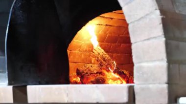 Odun sobada yanıyor. Pizza, ekmek ve diğer yemekleri hazırlamak için bir restoranda odun fırını.