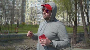 Gözlüklü adam müzik dinler ve dans eder.