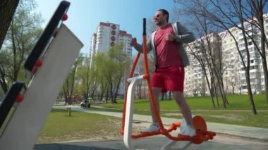 Komik adam spor sahasında fiziksel egzersiz yapıyor. Sporcu kardiyo egzersizi yapıyor. Açık hava spor salonunda gözlüklü adam egzersizi yapıyor.