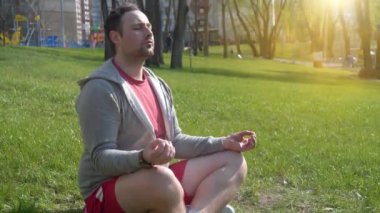 Adam sabahları parkta meditasyon yapıyor. Sporcu çimlere oturur ve antrenmandan önce meditasyon yapar. Meditasyon - bireyin zihni çalıştırdığı, eğittiği ya da bir bilinç biçimini tetiklediği uygulama