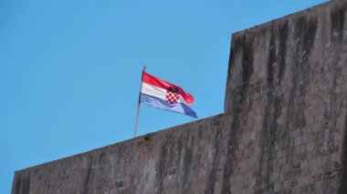 Eski Dubrovnik kentinin duvarlarında Hırvatistan bayrağı asılı. Hırvatistan Ulusal Bayrağı - Trobojnica veya The Tricolor, ortasında Hırvatistan 'ın Kolları Paltosu bulunan kırmızı, beyaz ve mavinin yatay üç renkli rengi
