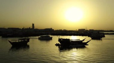 Eski Doha kasabası Katar 'da gün batımında liman, Basra Körfezi, Arap Yarımadası, Orta Doğu. Doha - Katar 'ın başkenti ve en kalabalık şehri. Dhow - geleneksel ahşap Katar teknesi