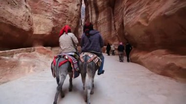 JORDAN, PETRA, 12 ARALIK 2016: Ürdünlüler Siq 'te bir eşeğe biniyor - Ürdün Haşim Krallığı' nın tarihi ve arkeolojik kenti Petra 'ya açılan dar geçit ve geçit