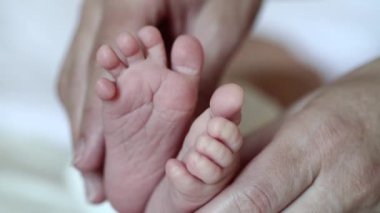 Anne eli ve bebek ayağı. Bir aylık erkek bebek. Annem küçük bebek ayaklarını elinde tutuyor.