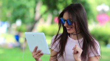 Güzel kız tablet bilgisayarla iletişim kuruyor. Beyaz tabletli çekici bir kadın Skype ya da görüntülü sohbet yoluyla iletişim kuruyor, tabletli bir kadın akıllı telefonla konuşuyor.