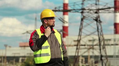 Isı santralindeki işçiler radyo istasyonu aracılığıyla iletişim kuruyor. Elektrik santralinde taşınabilir radyo vericisi olan güçlü bir adam.