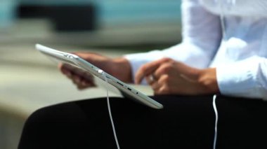 Kadın kapalı çekimde tablet bilgisayar kullanıyor. Fransız manikürlü kadın elleri tablet bilgisayarı tutuyor.