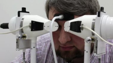 Göz hekimliği kliniğindeki hasta. İnsan sinnoflora bakar. Göz kaslarındaki dengesizliği teşhis etmek ve onları ortopedik yöntemlerle tedavi etmek, Strabismus tedavisinde kullanılır.