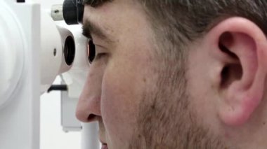 Göz hekimliği kliniğindeki hasta. İnsan sinnoflora bakar. Göz kaslarındaki dengesizliği teşhis etmek ve onları ortopedik yöntemlerle tedavi etmek, Strabismus tedavisinde kullanılır.