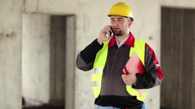 İnşaat alanında akıllı telefonu olan bir inşaatçı. İnşaat alanındaki inşaat konuşmalarında sarı sapkalı iş belgeleriyle çalışan ustabaşı. İnşaatçı proje sitesindeki cep telefonundan konuşuyor